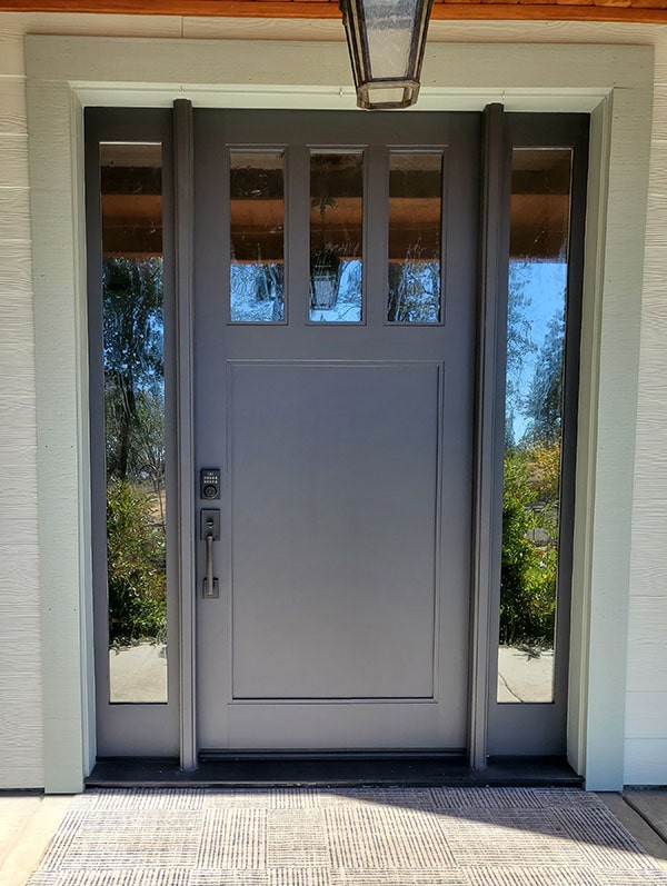 grey front door surrounded by glass with light grey trim