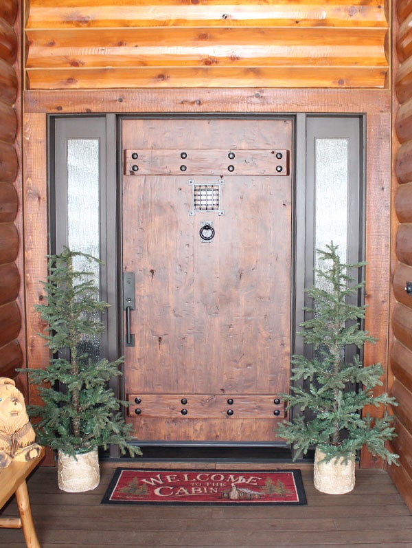 the front porch of a cabin style home with fresh staining